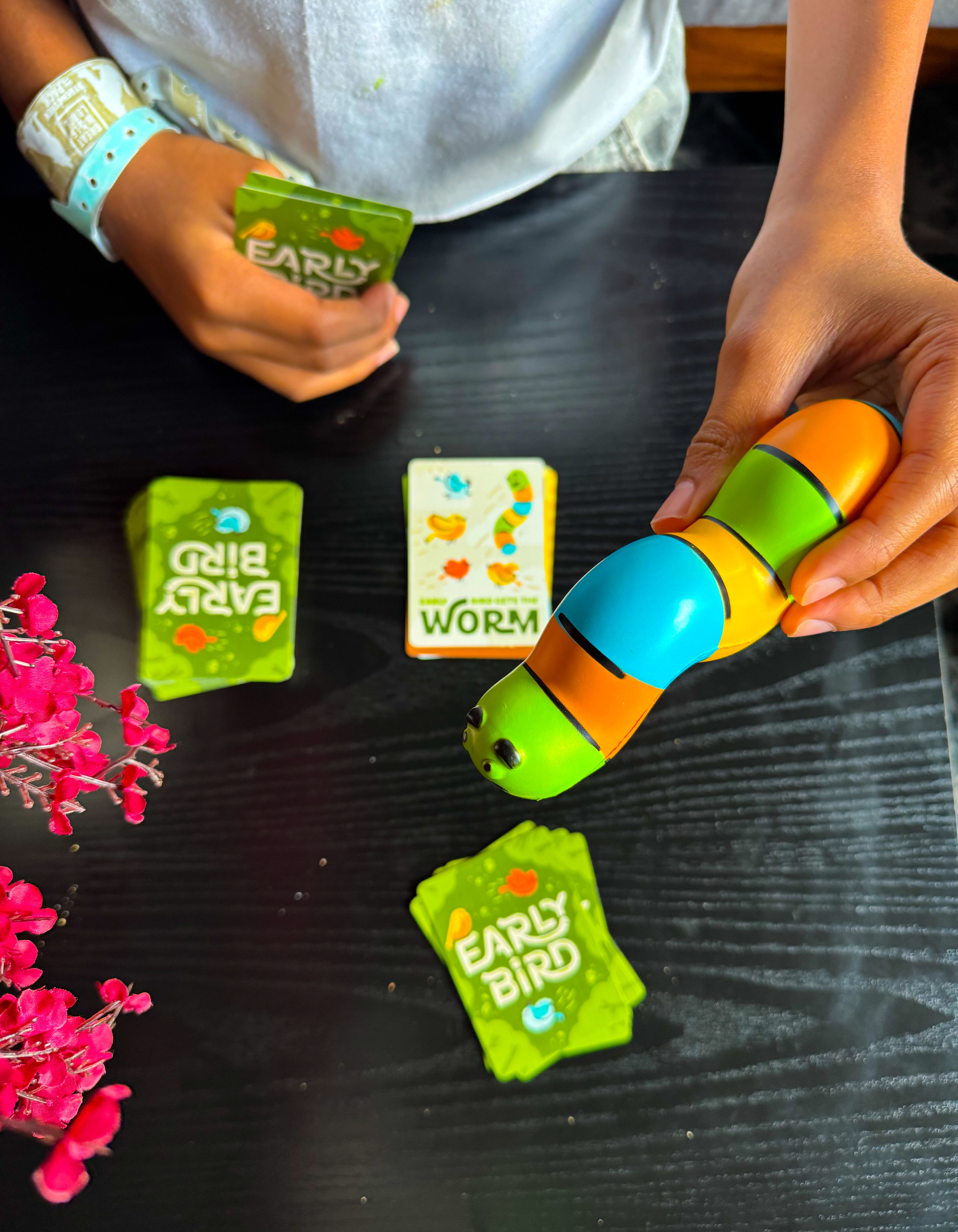 Child holding the colorful squishy worm game piece from Early Bird