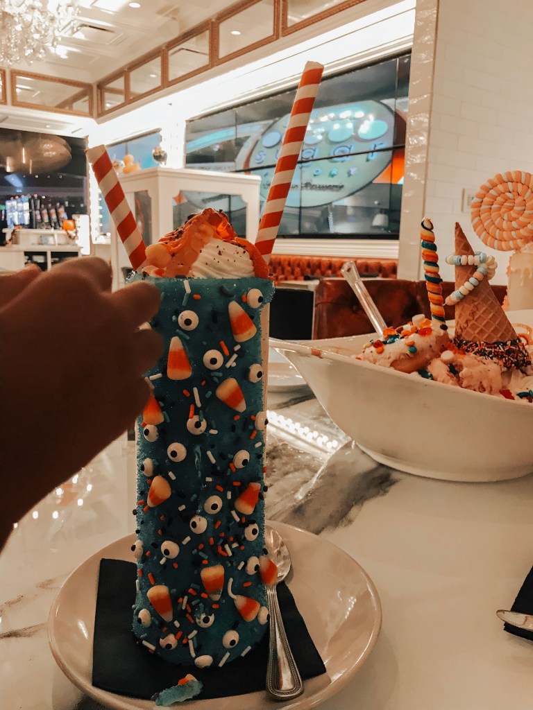 Halloween-themed monster milkshake decorated with candy and whipped cream at Sugar Factory Biloxi.