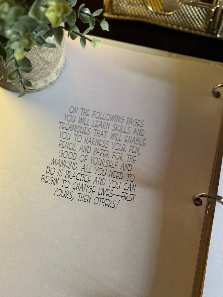 A close-up of a page from an art curriculum binder featuring motivational text about learning drawing skills and techniques, with a green plant in the foreground.