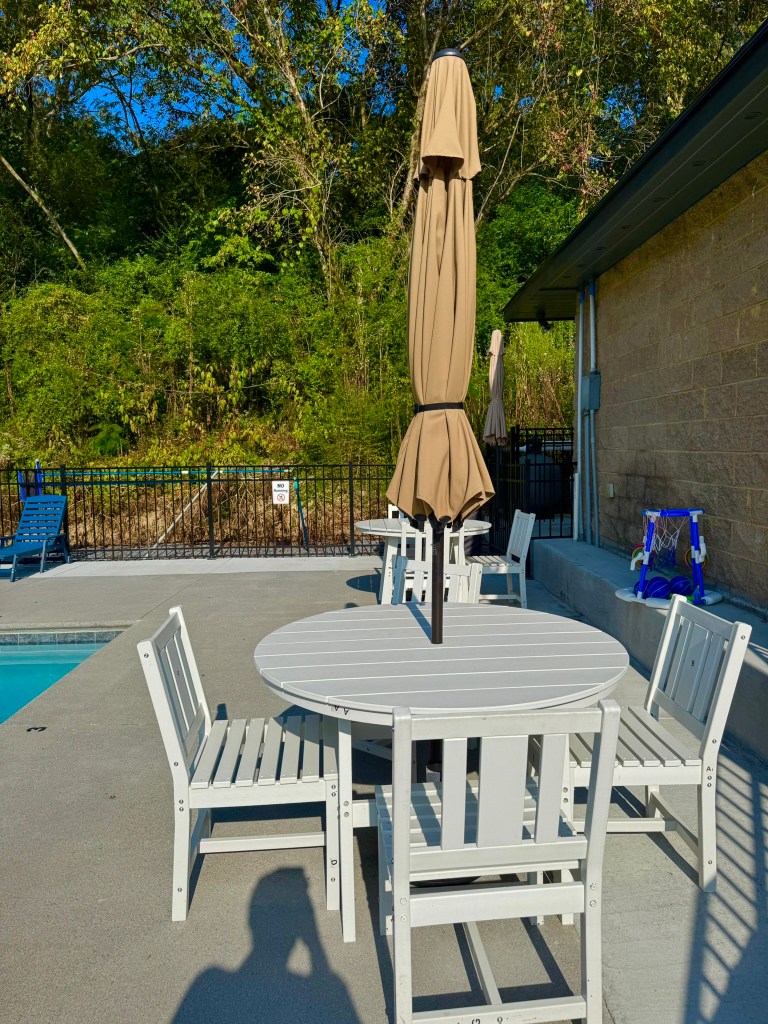 Outdoor tables and seating beside the pool at Jellystone Park Pigeon Forge