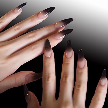Sleek stiletto nails featuring a black ombre design that fades from nude to jet-black tips, showcasing an elegant and witchy aesthetic.
