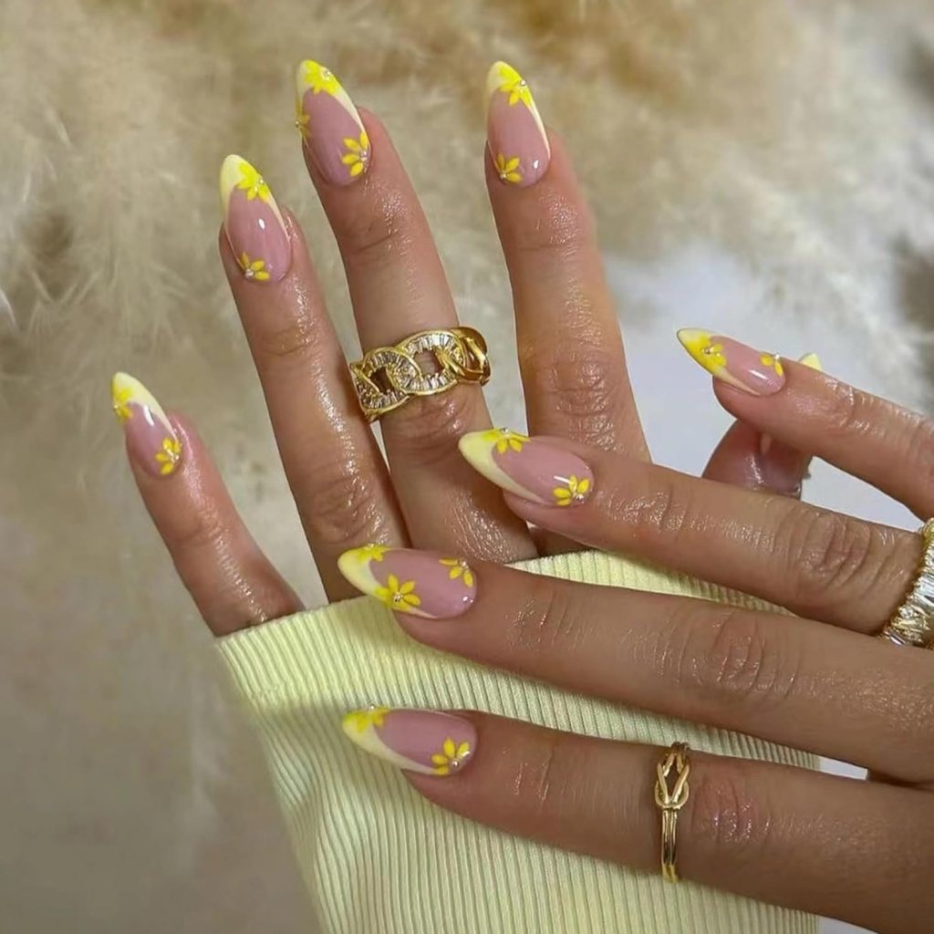 Butter yellow daisy French tip nails with floral nail art and glossy almond shaped manicure design