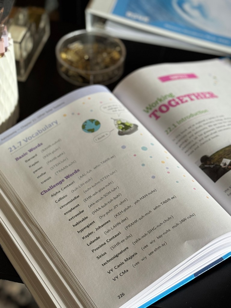 Close-up of an open textbook page featuring a vocabulary section with terms related to science, including plant illustrations and highlighted headings.