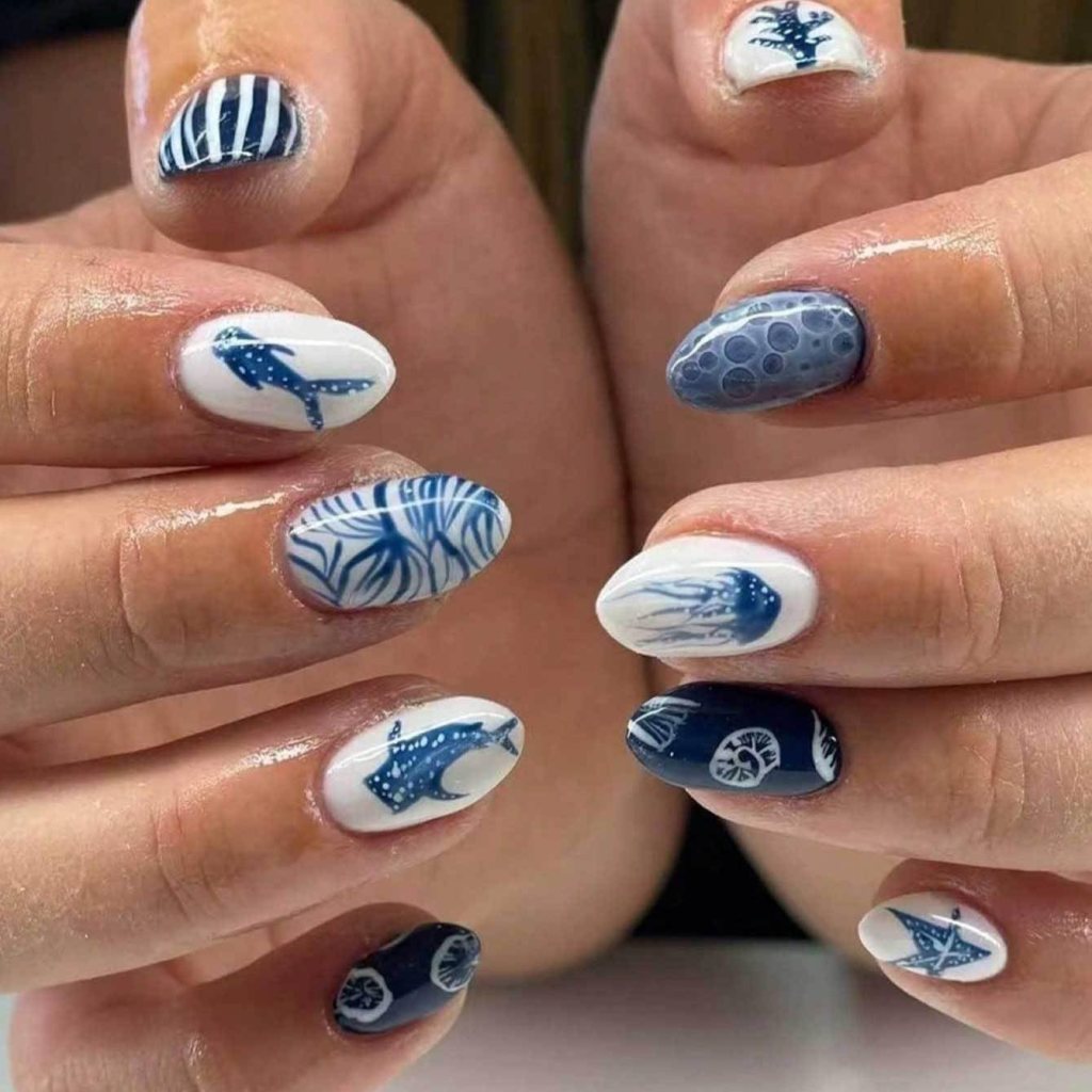 Blue ocean-inspired nails with whale art, jellyfish details, seashell accents, and nautical summer manicure ideas