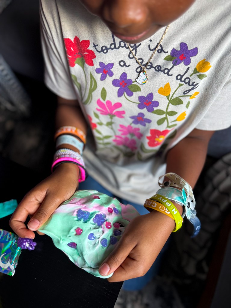 Tween girl creating her own Gui Gui slime combination with decorations, mix-ins and mini figures from the Mega Slime Haul.