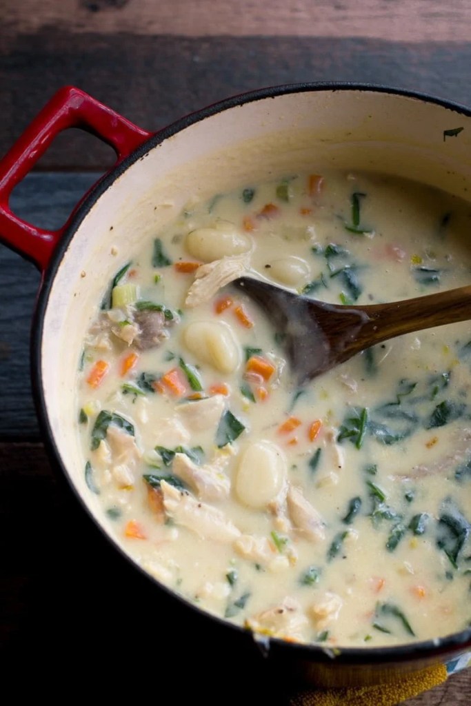 Creamy turkey gnocchi soup with tender gnocchi, spinach, and carrots served in a rustic bowl