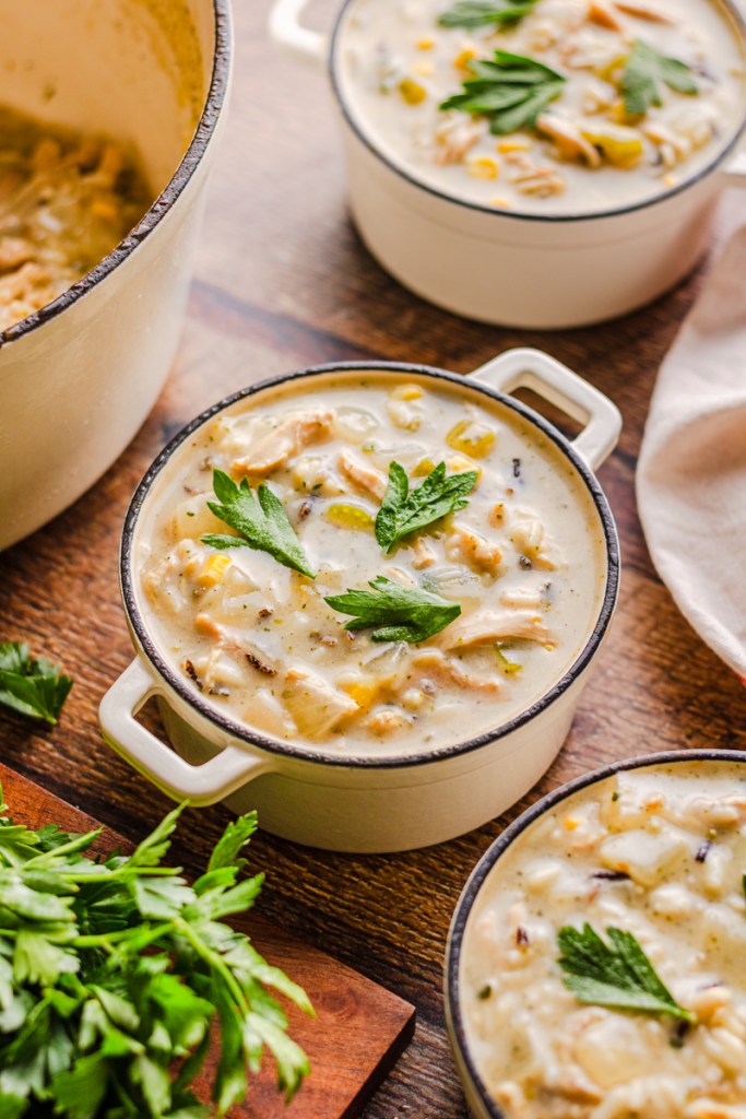 Homemade copycat Panera chicken and wild rice soup garnished with fresh herbs