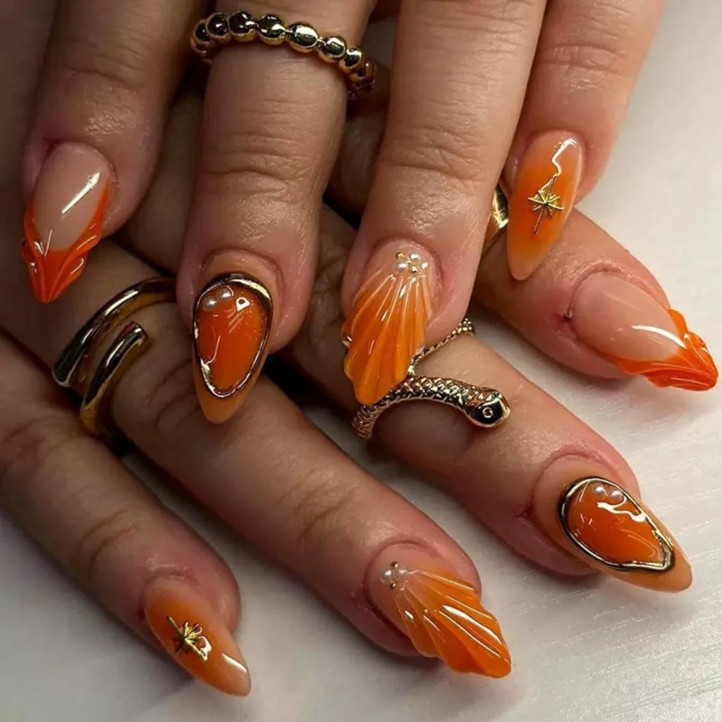 Almond acrylic nails with orange tones, chrome accents, and 3D textured nail art
