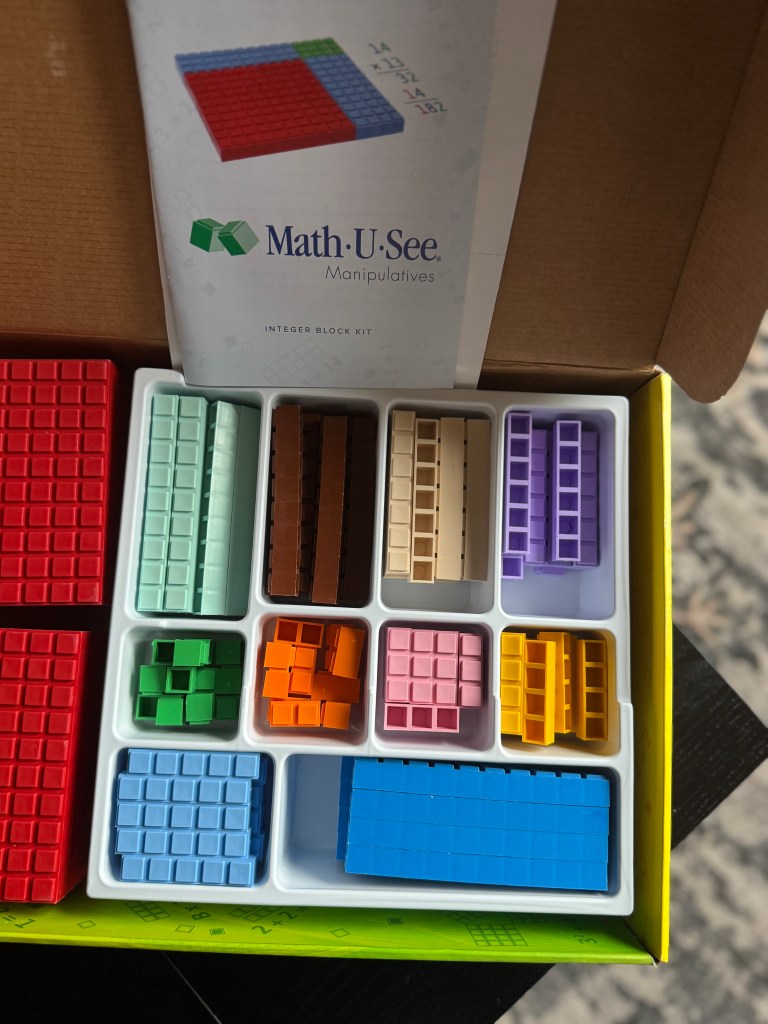 Overview of the Math-U-See Integer Block Kit, featuring various colored manipulatives arranged in a tray, including blocks for visual and hands-on learning.
