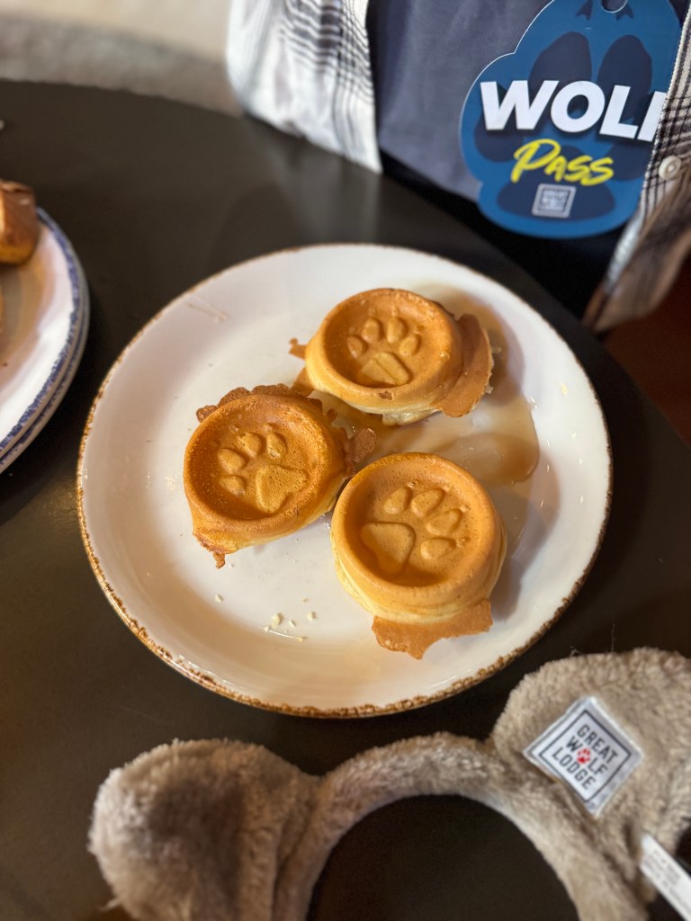 Three paw-print waffles served on a plate, with a Great Wolf Lodge branded item visible in the foreground.