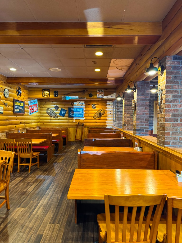 Cozy wooden dining booths with red cushioned seats and vintage farmhouse decorations at Flapjack's Pancake Cabin.