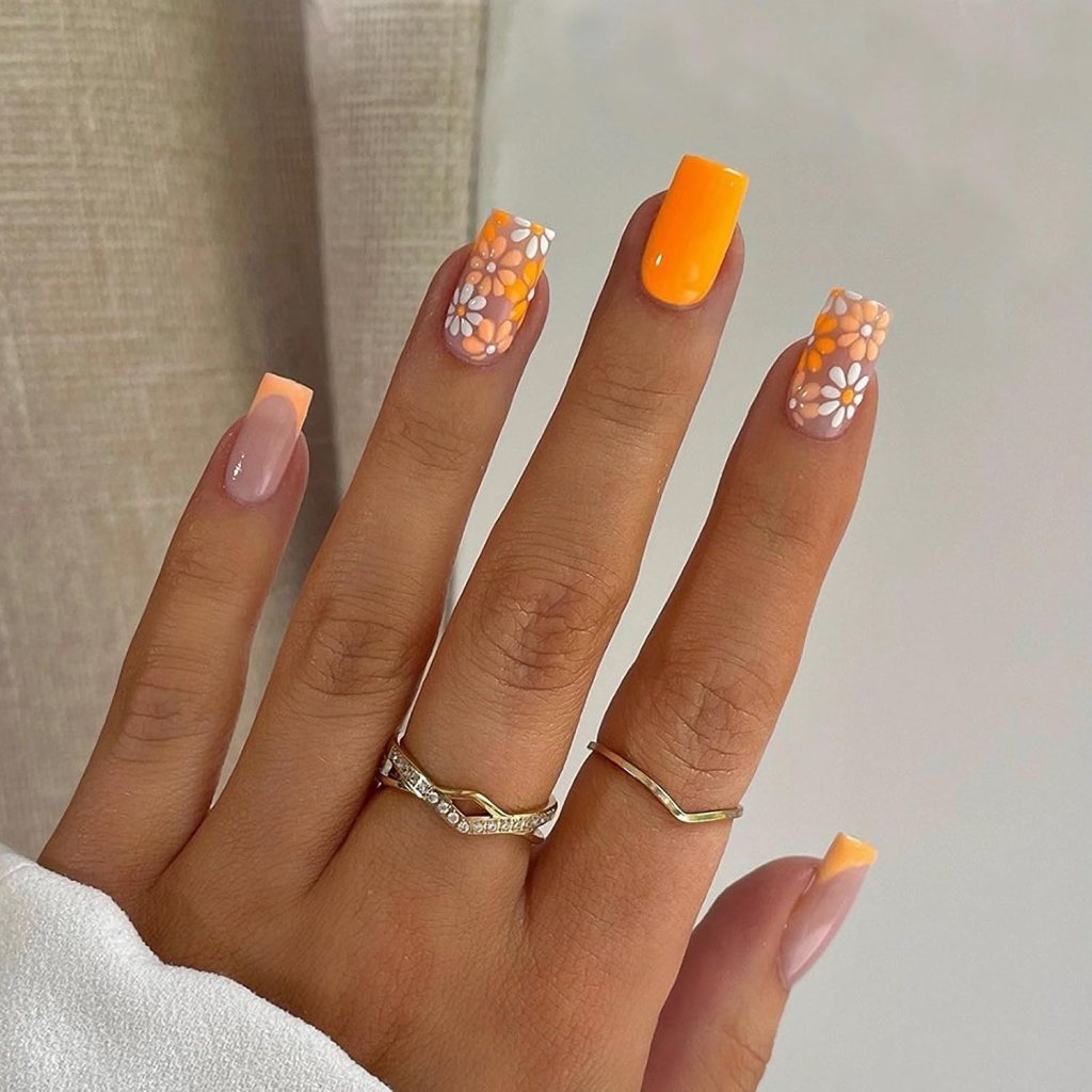 Square nails with orange polish and white daisy flower nail art