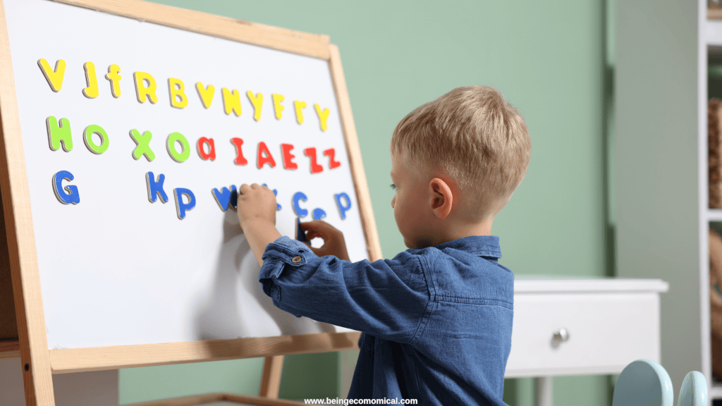 Preschool child using magnetic alphabet letters on a whiteboard for letter recognition practice