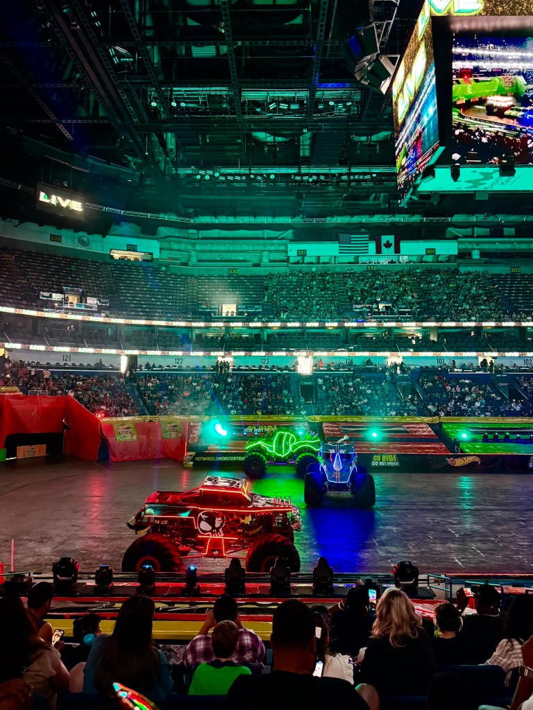 Illuminated monster trucks enter the arena during the Glow-N-Fire opening in New Orleans.