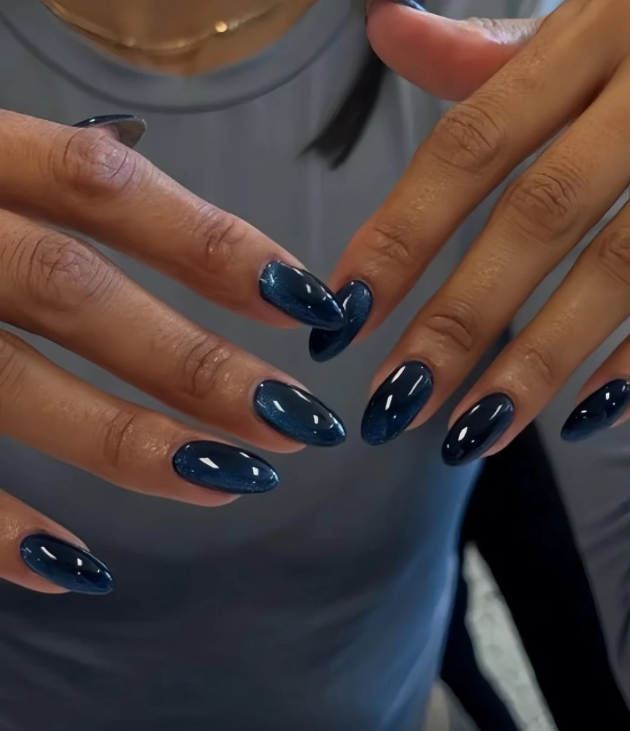 Glossy midnight navy blue almond nails with a sleek dark blue manicure and shiny almond-shaped nail design.