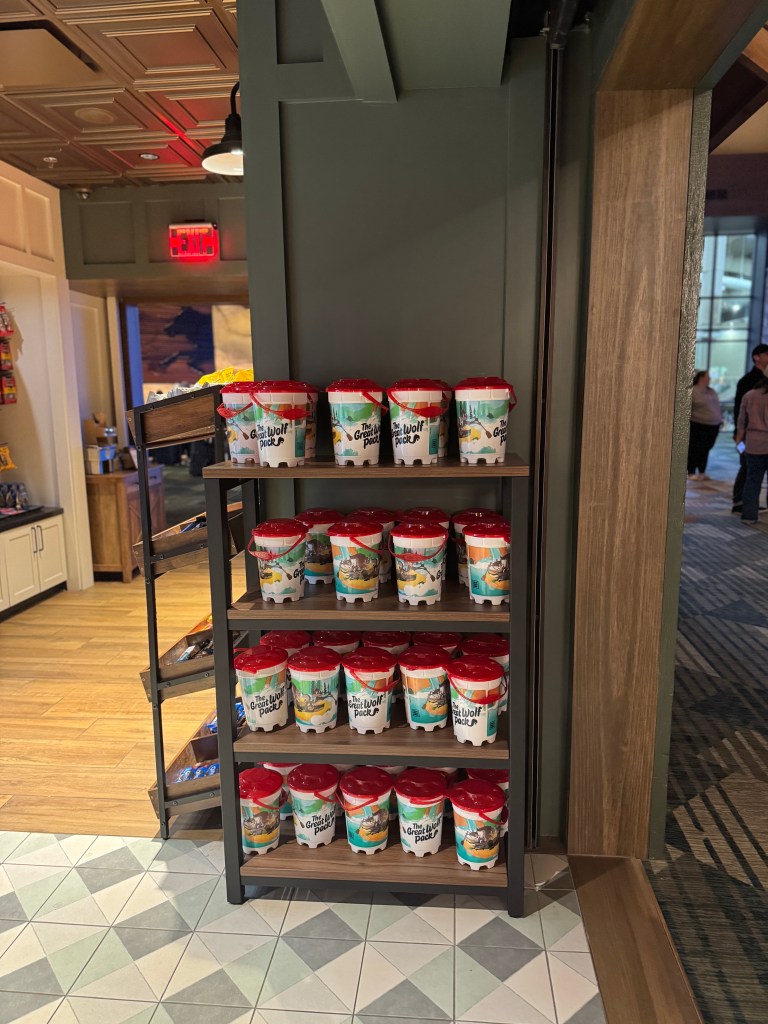 A shelf displaying colorful ice cream buckets with various designs for Great Wolf Lodge snacks and treats, creating a fun and inviting atmosphere.
