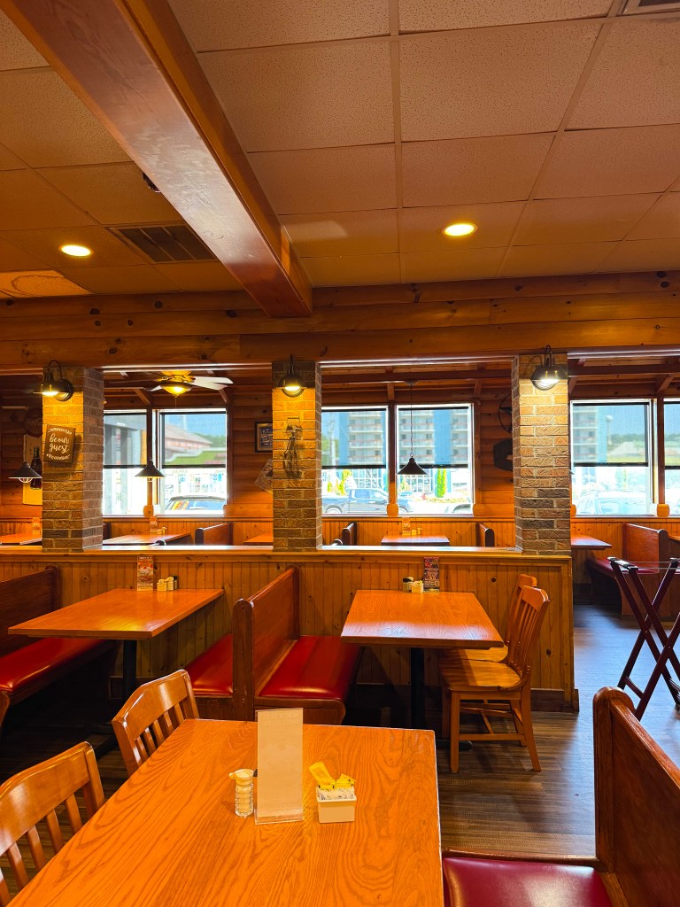 Vintage Coca-Cola sign displayed on a wooden log cabin wall inside Flapjack's Pancake Cabin restaurant.
