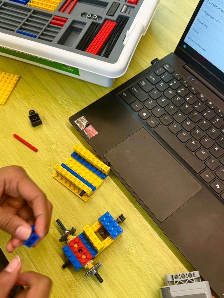 Student building an iBrick STEM project with laptop instructions