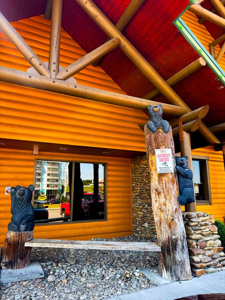 Wooden bear carvings and rustic bench outside Flapjack's Pancake Cabin in Pigeon Forge, Tennessee.