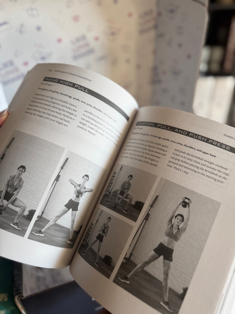 An open fitness book displaying exercises, with images illustrating the movements of a woman performing various exercises, including the Hang High Pull and Stretch, Pull, and Push Press.