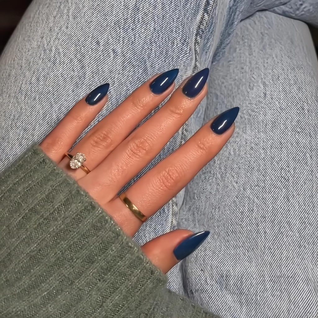 Solid glossy navy blue almond nails with a sleek dark blue manicure and minimalist aesthetic.