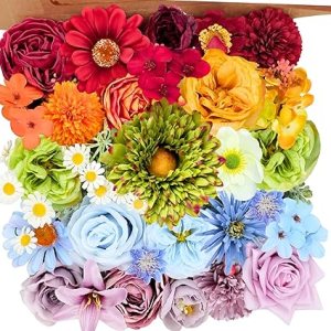 A colorful assortment of artificial flowers in various shades, including reds, yellows, greens, and blues, arranged flat in a vibrant display.