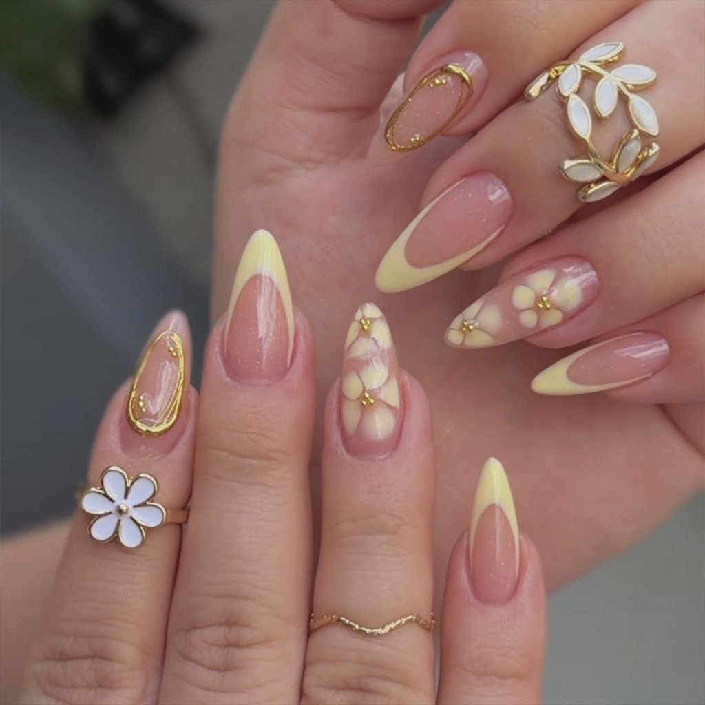 Elegant butter yellow floral French tip nails with delicate flower nail art and glossy almond manicure finish