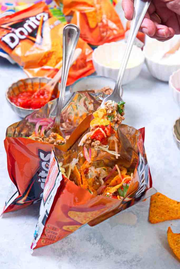 Walking tacos served in chip bags with taco meat, cheese, and toppings for a fun family dinner.