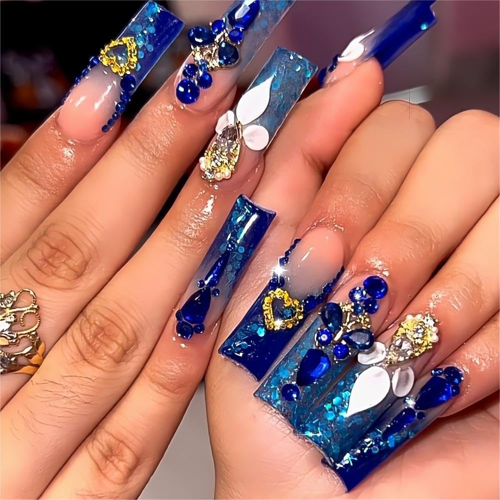 Royal blue glitter square nails with rhinestones, chunky gems, glitter polish, and luxury acrylic nail art.