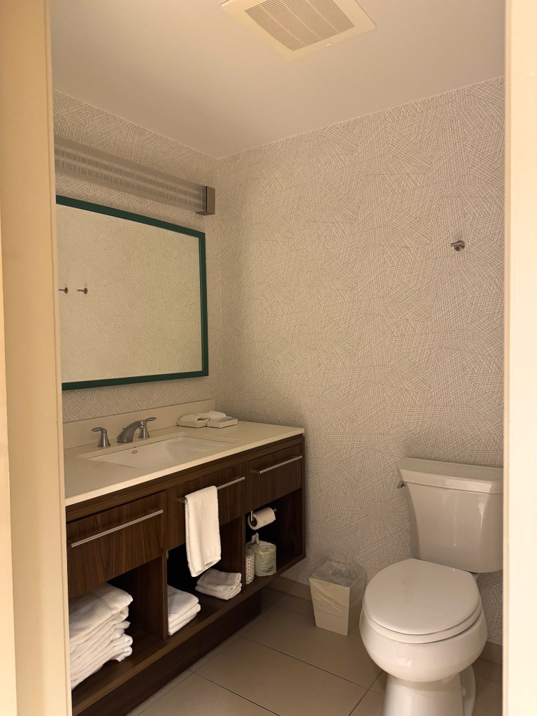 Guest suite bathroom with vanity, towels, sink and toilet at Home2 Suites Pigeon Forge.