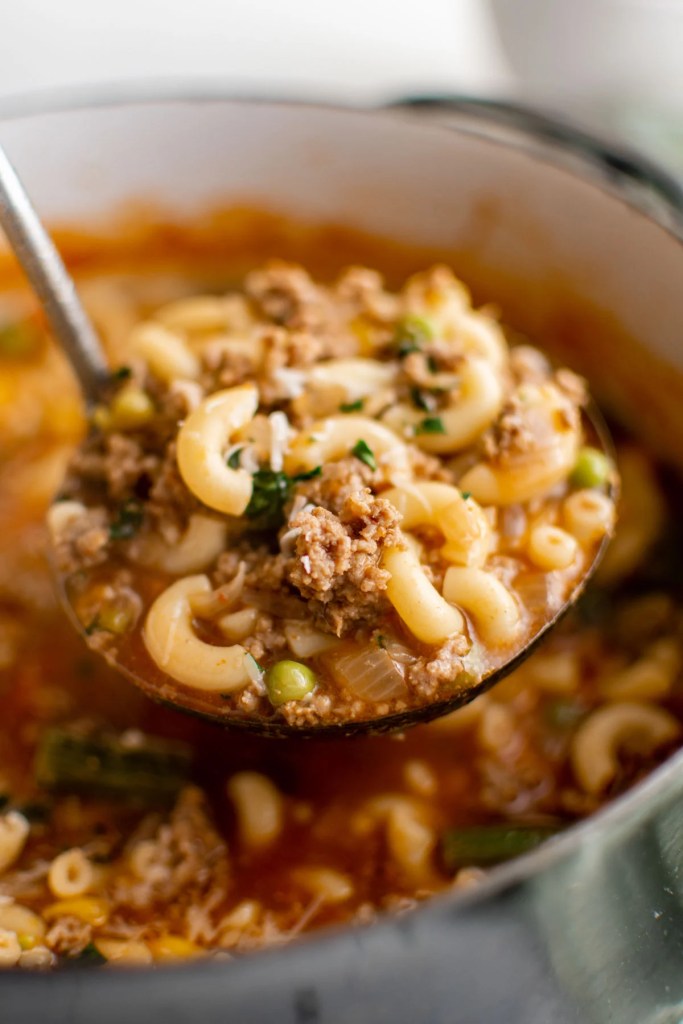 Hearty hamburger soup with ground beef, potatoes, carrots, and tomatoes served in a rustic bowl