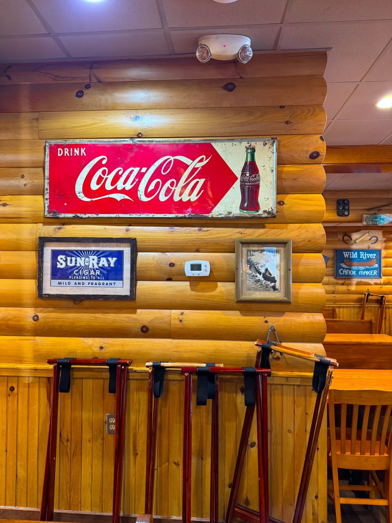 Vintage fishing signs and outdoor memorabilia decorating the wooden walls of Flapjack's Pancake Cabin in Pigeon Forge.