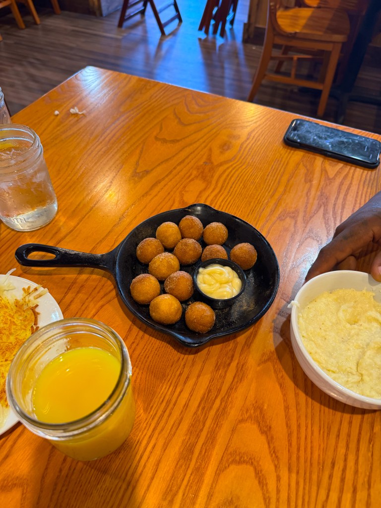 Golden cinnamon-sugar Flapjack Fritters served in a cast-iron skillet with cream cheese icing for dipping.