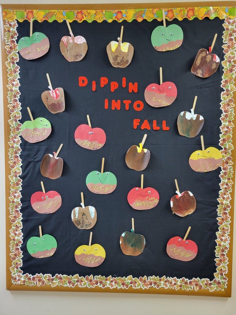 Dippin’ Into Fall bulletin board featuring colorful student-made caramel apple crafts and an autumn leaf border.