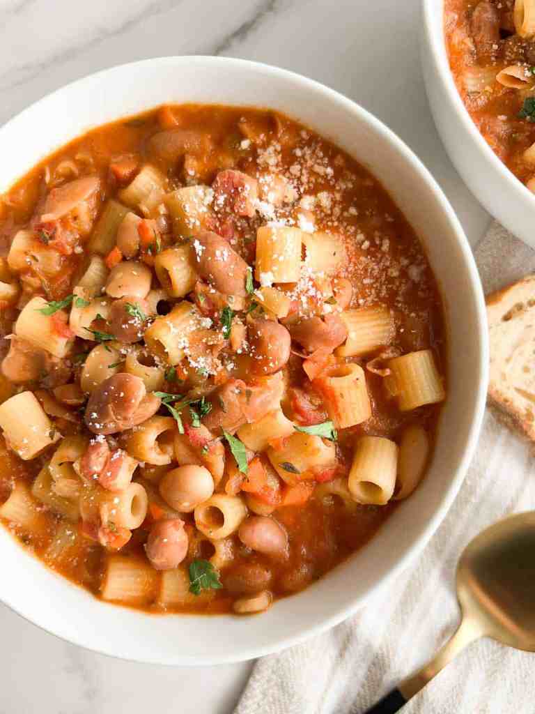 Classic Italian pasta e fagioli soup with ditalini pasta, beans, tomatoes, and fresh herbs served in a rustic bowl