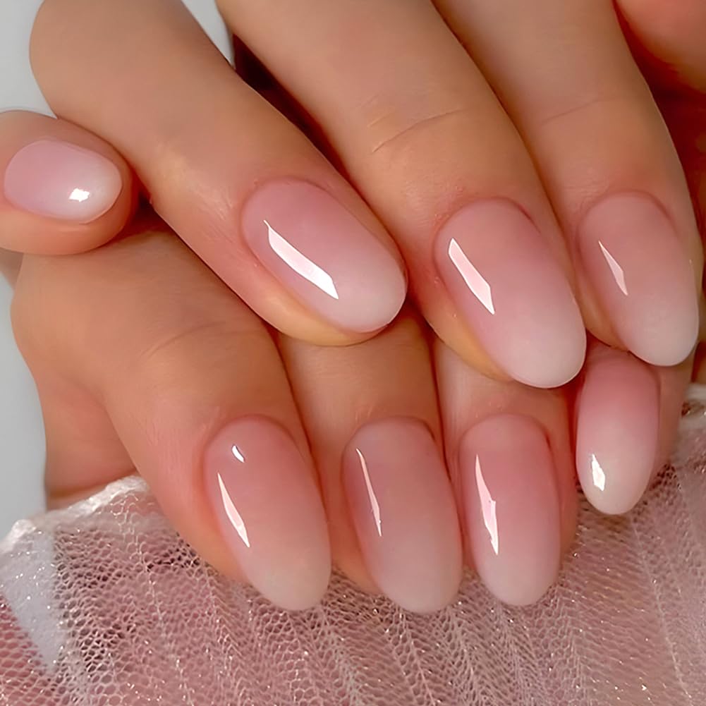 Close-up of hands with manicured nails featuring a soft pink ombre design.
