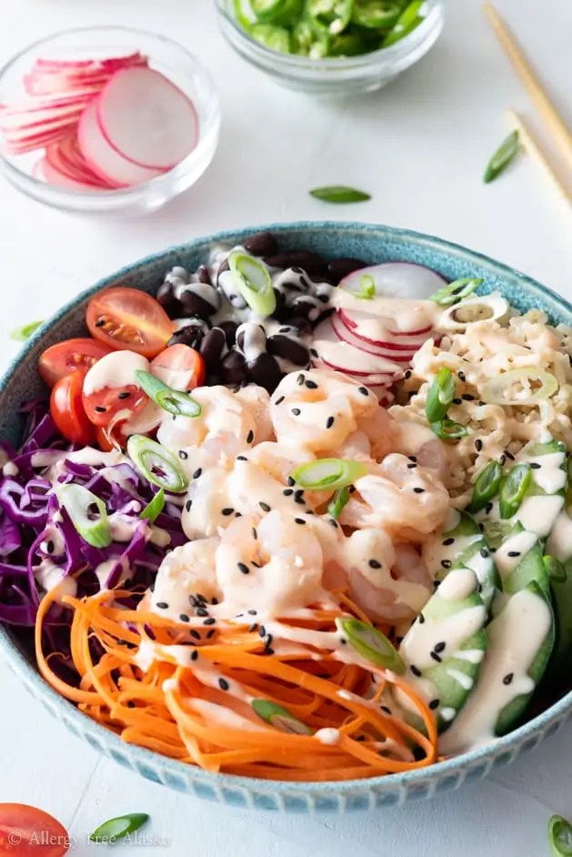 Shrimp poke bowl with rice, vegetables, and spicy sauce for a healthy dinner