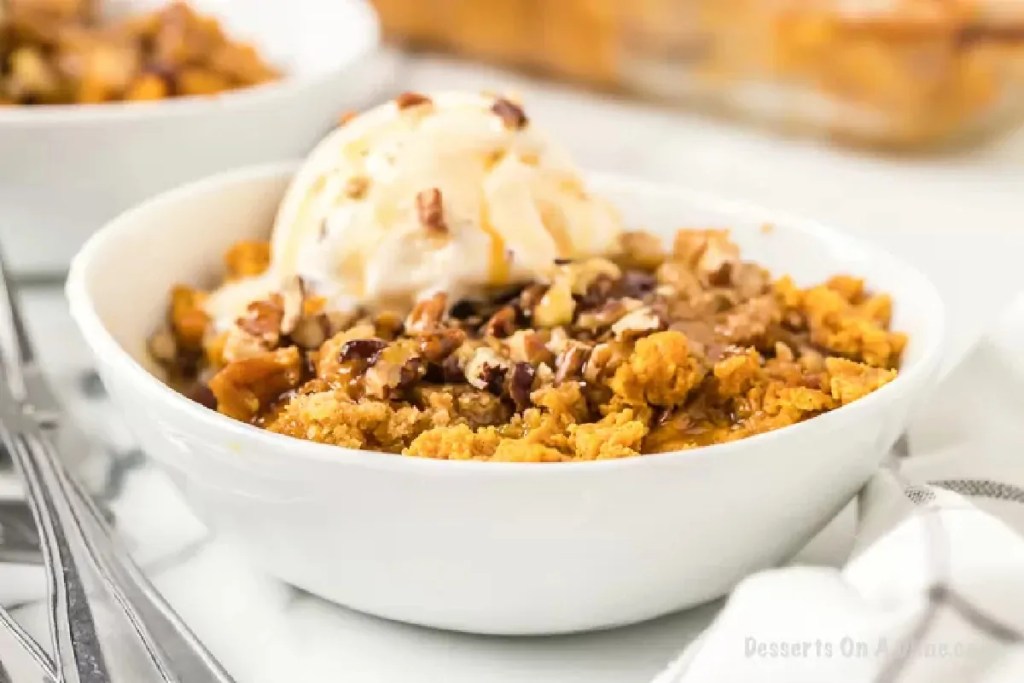 Warm pumpkin cobbler topped with vanilla ice cream – cozy fall dessert recipe.