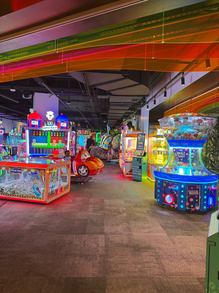 Interior view of an arcade at Great Wolf Lodge featuring colorful game machines, ticket counters, and prizes, designed for family entertainment.