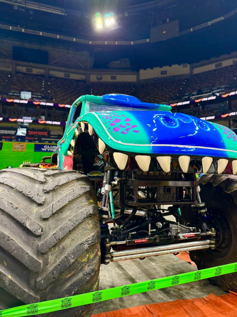 Close-up of the colorful Mega Wrex monster truck with large teeth and reptile-inspired details.