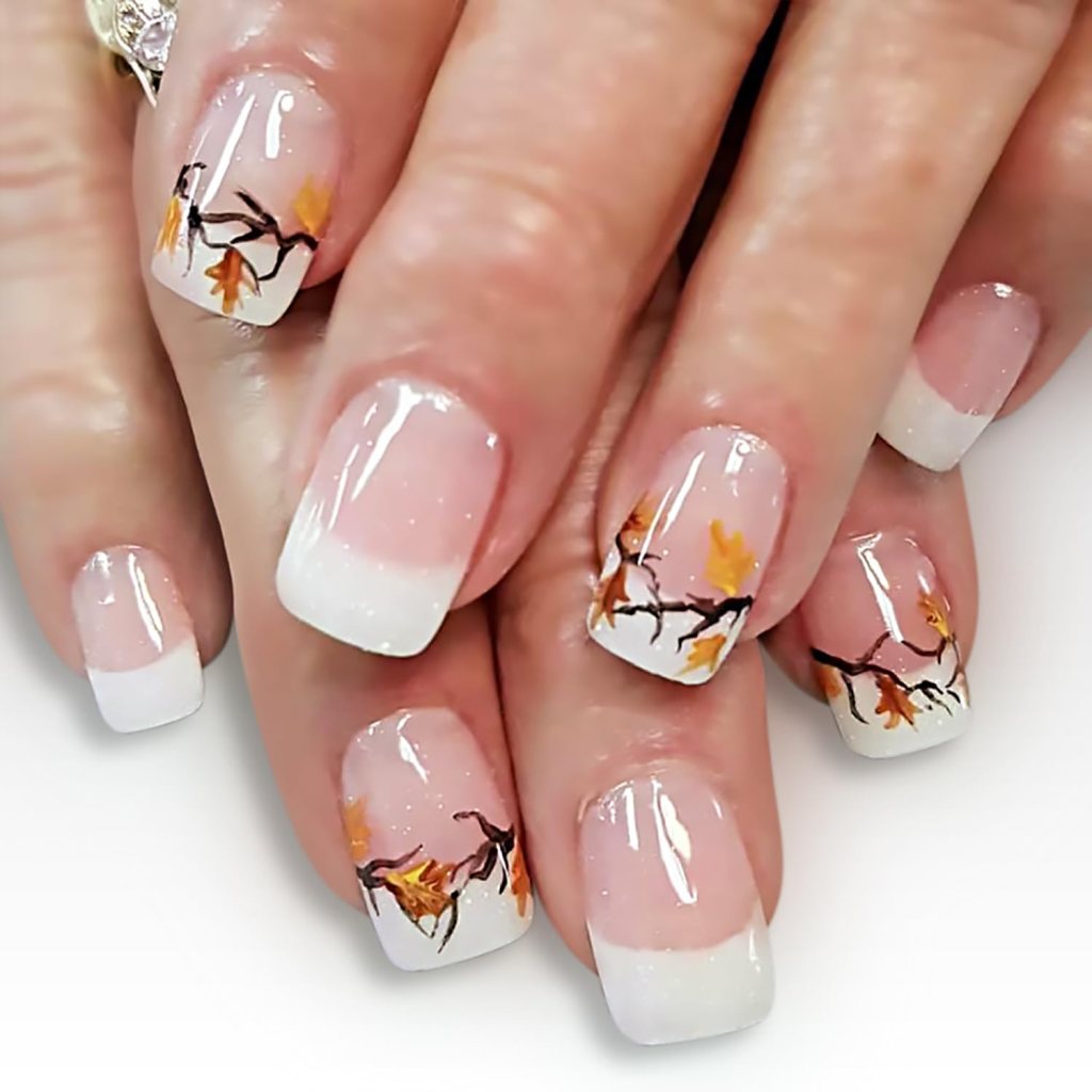Elegant French tip nails featuring hand-painted autumn branches with orange and yellow leaves, perfect for a festive Thanksgiving look.