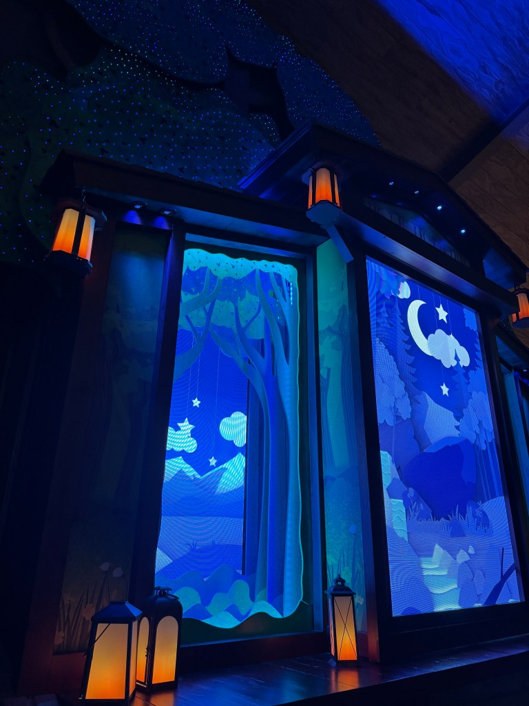 Illuminated lobby decor at Great Wolf Lodge featuring a stylized night scene with blue and green lighting and decorative lanterns.