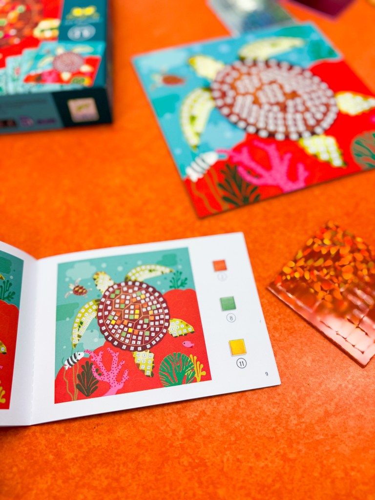 Djeco Caribbean Mosaics instruction booklet beside a partially completed turtle mosaic.
