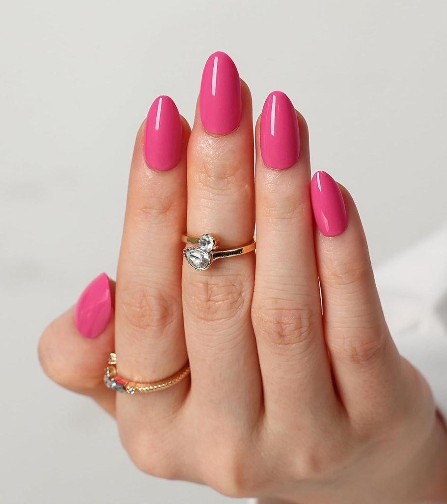 Hand displaying long, glossy pink nails adorned with rings on two fingers.