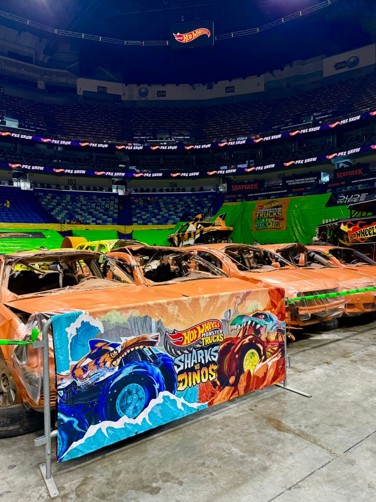 Close view of several flattened orange cars prepared for the monster truck show.