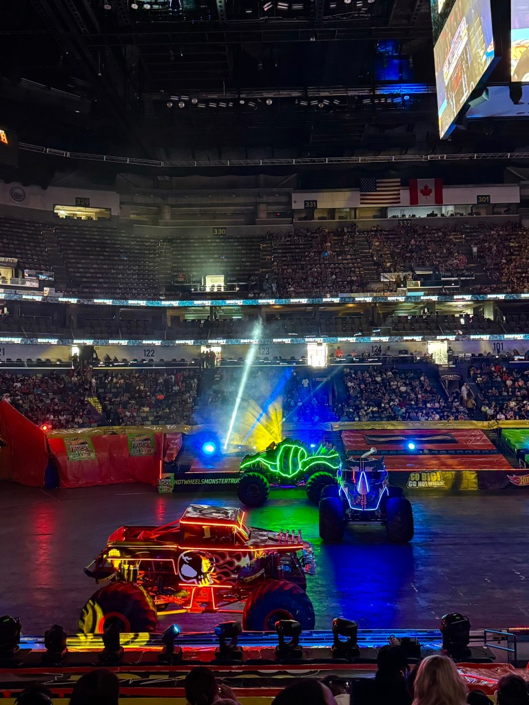 Illuminated monster trucks enter the arena during the Glow-N-Fire opening in New Orleans.