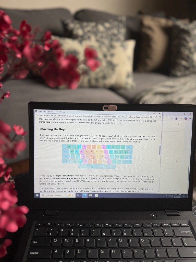 Laptop displaying typing skills lessons with a color-coded keyboard diagram and text explaining finger positioning on the keyboard.
