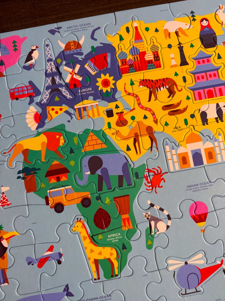 Close-up of Africa, Europe and Asia on a colorful world geography puzzle for kids.