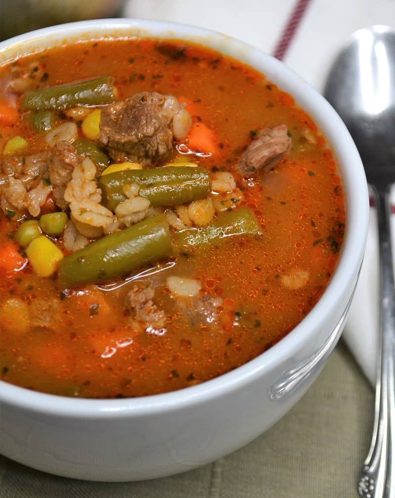 Hearty old-fashioned beef vegetable soup with tender beef chunks, potatoes, carrots, and green beans served in a rustic bowl