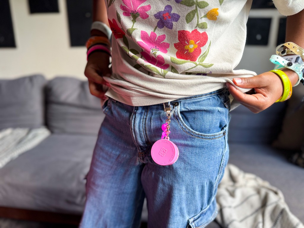 Gui Gui Lil Flutter mini slime keychain clipped onto a tween girl's jeans for an easy portable slime accessory.